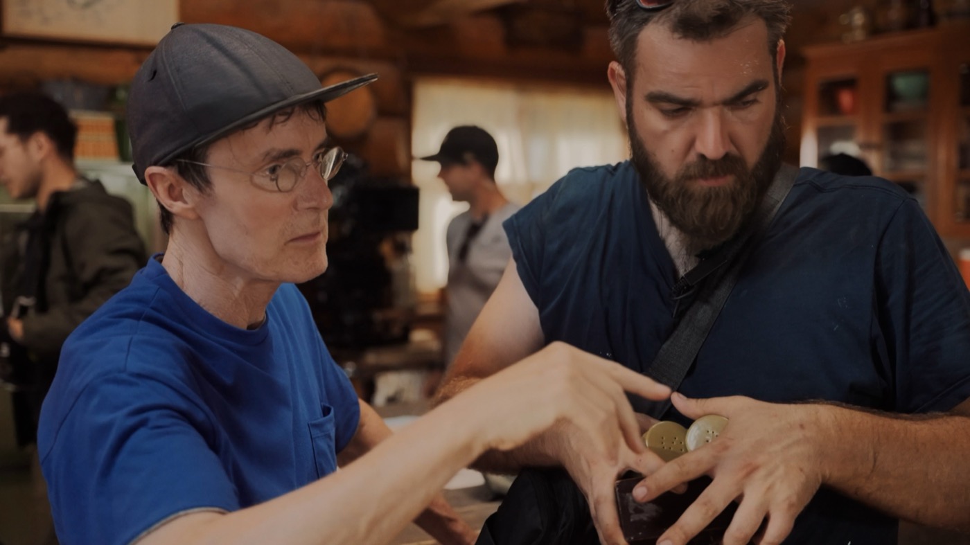 William Scoular reviewing a prop with a crew member on the set of Northbound